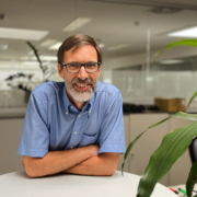 Franz Oberpeilsteiner, Head of Product Center, Motors & Drives an Stehtisch angelehnt neben einer Pflanze